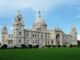 Kolkata Photo Fort, "Victoria Memorial in Kolkata, India, a large white marble building with domes and towers, set against a blue sky."